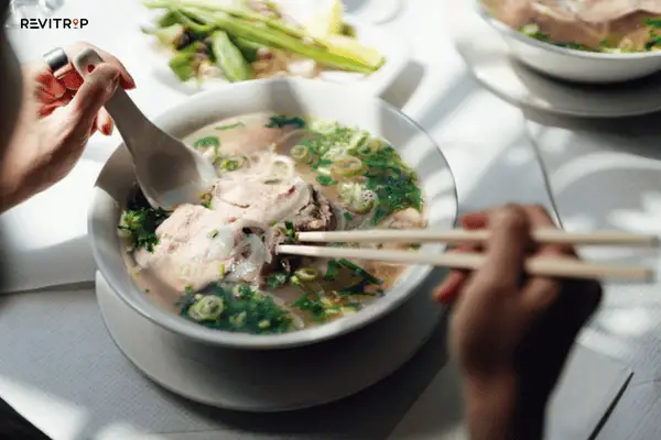 Pho recipe: How to eat pho correctly using chopsticks and soup spoon to combine noodles, beef and broth in one bite
