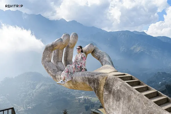 Swing Sapa giant stone hand reaching up from hillside surrounded by mist and mountain forest